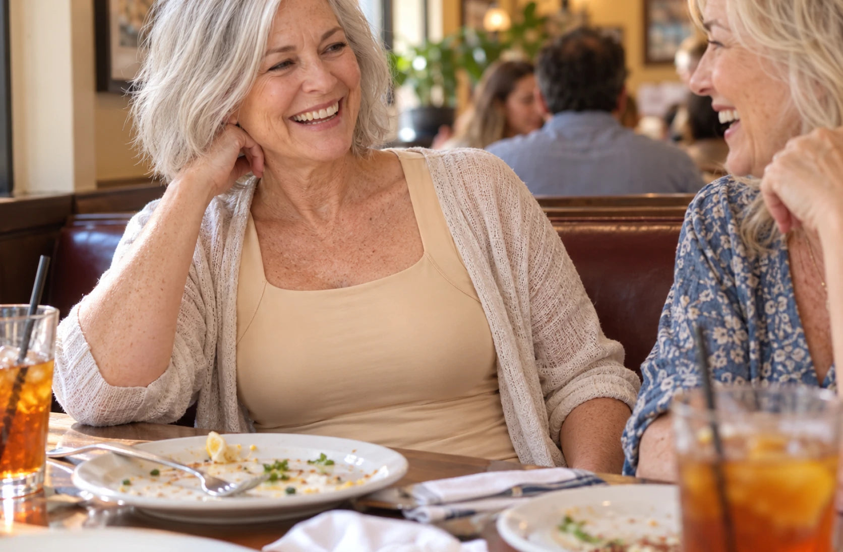Woman relaxing at lunch with friends, wearing Maggie’s Tank under her top